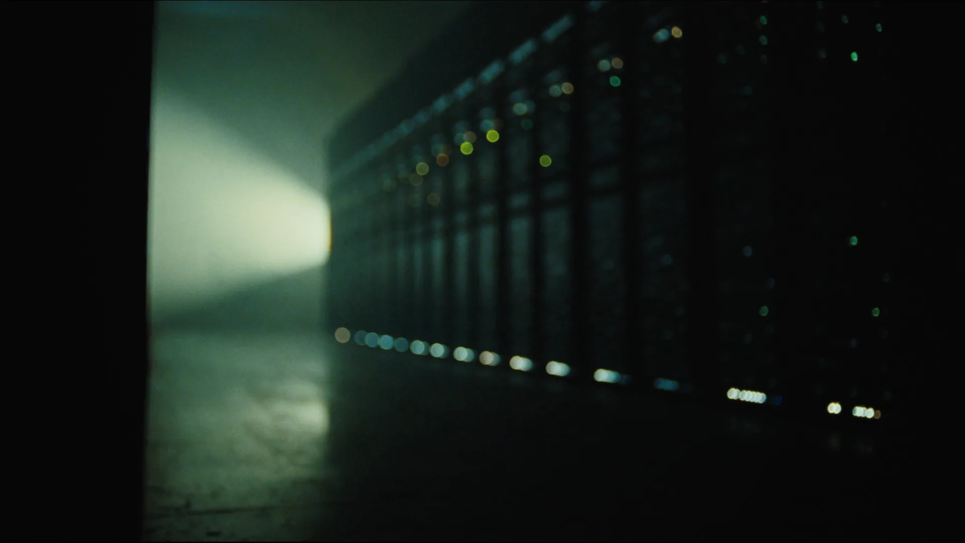 A moody data hall with server racks receding into the distance