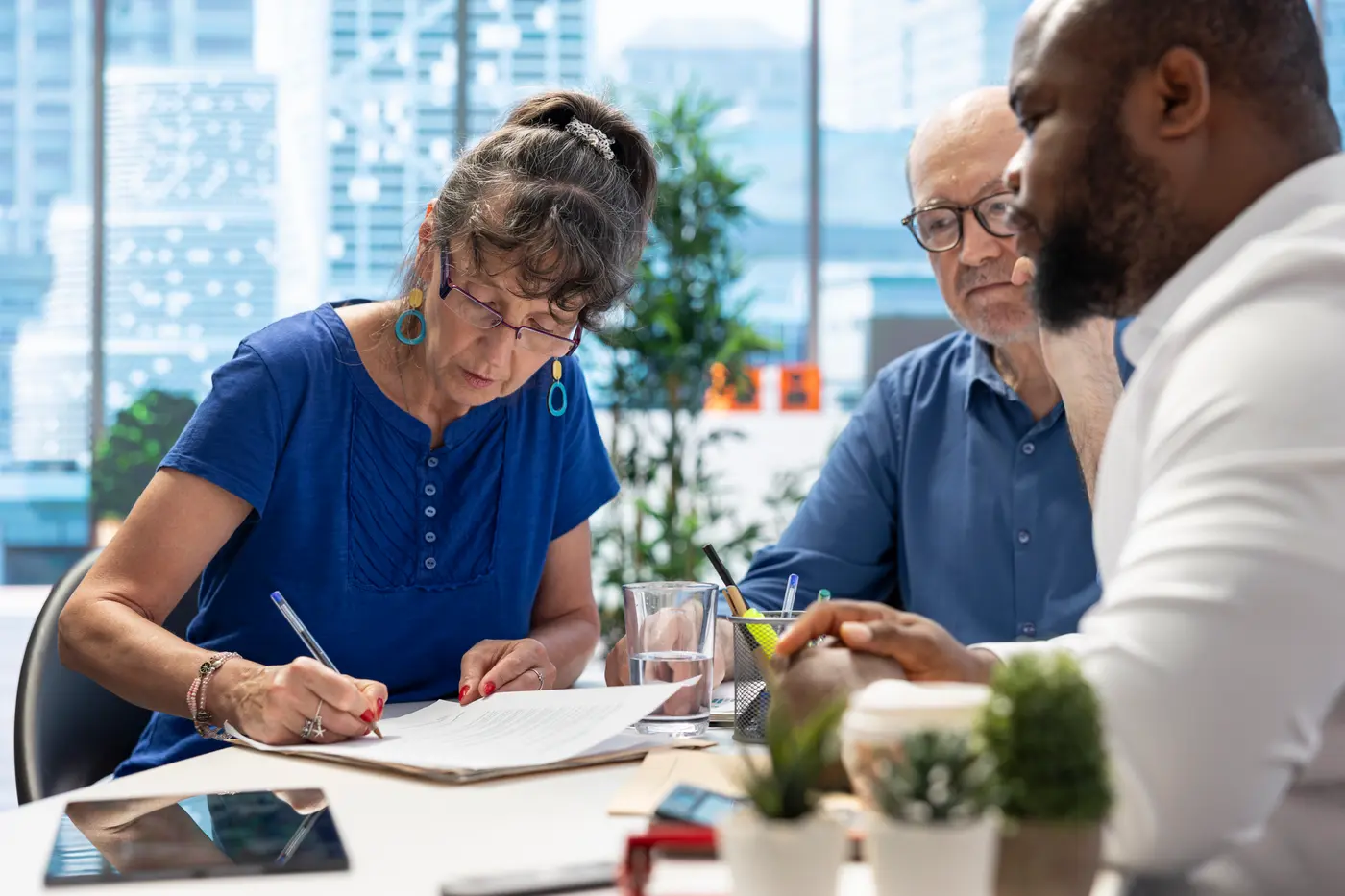 Three colleagues discussing work around a table